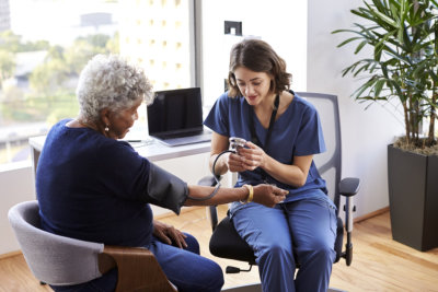 a nurse checking a senior's blood pressure
